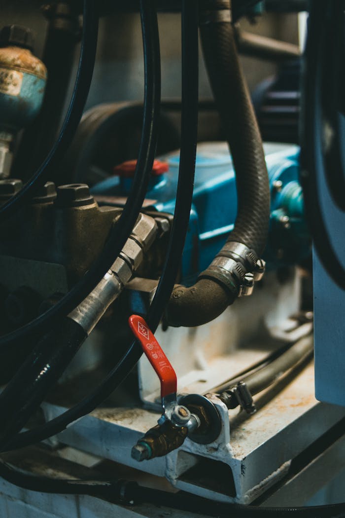 Detailed view of an industrial engine showcasing hoses, levers, and painted parts.